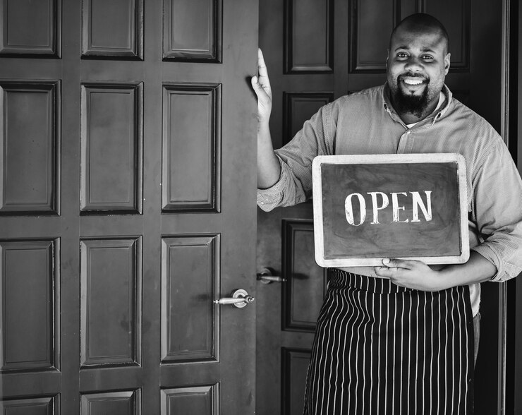 cheerful-small-business-owner-with-open-sign_53876-26185